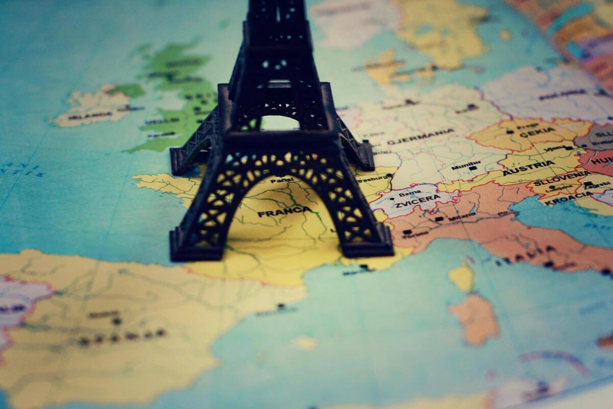 Eiffel Tower miniature on Map of Europe representing travel planning to Paris