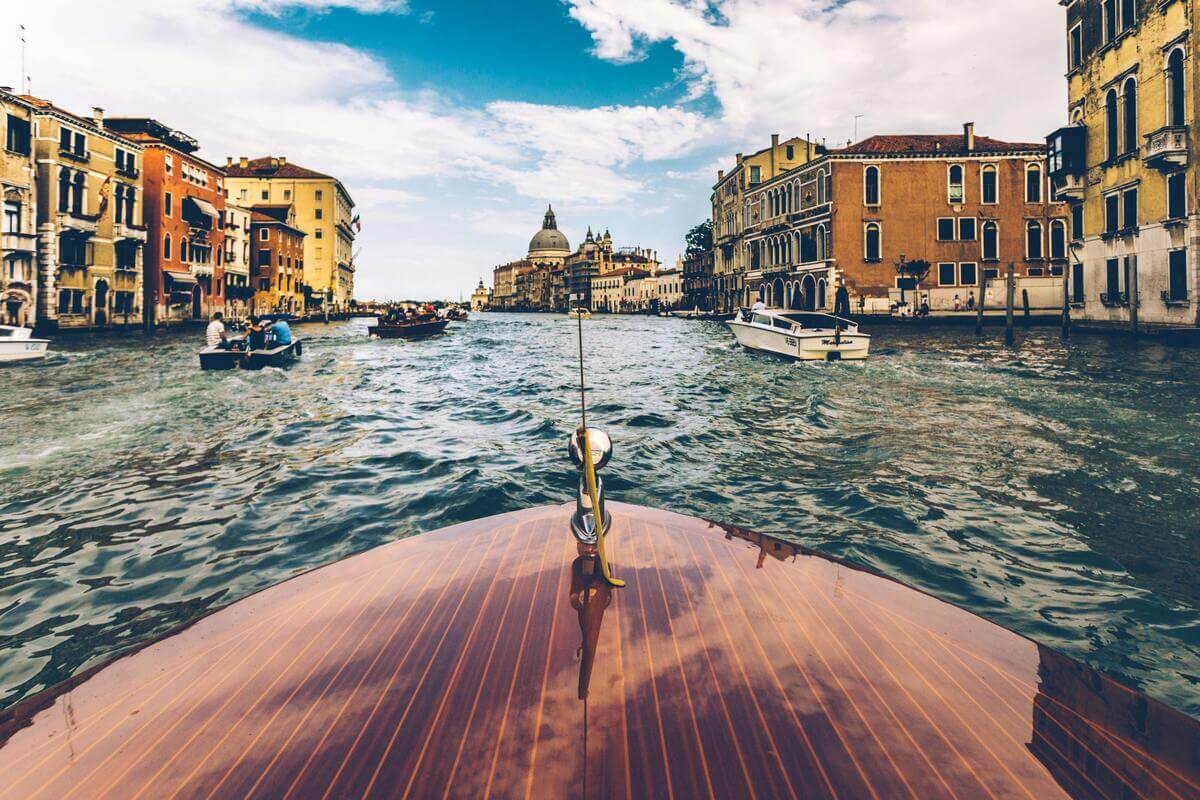 Boat cruising along the Grand Canal in Venice with historic buildings, one of the most romantic cities in Europe for couples