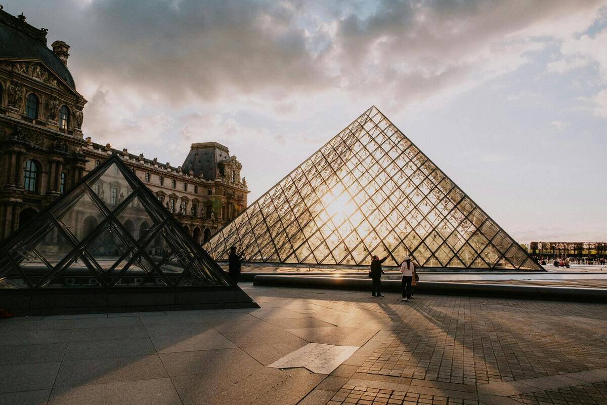Couples on romantic stroll overlooking the louvre in the evening