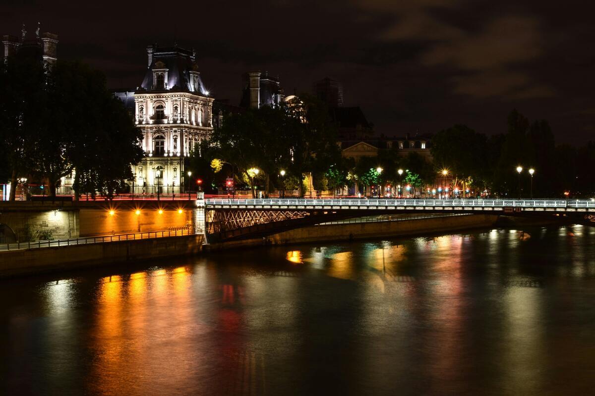 Paris at night overlooking flowing water romantic view