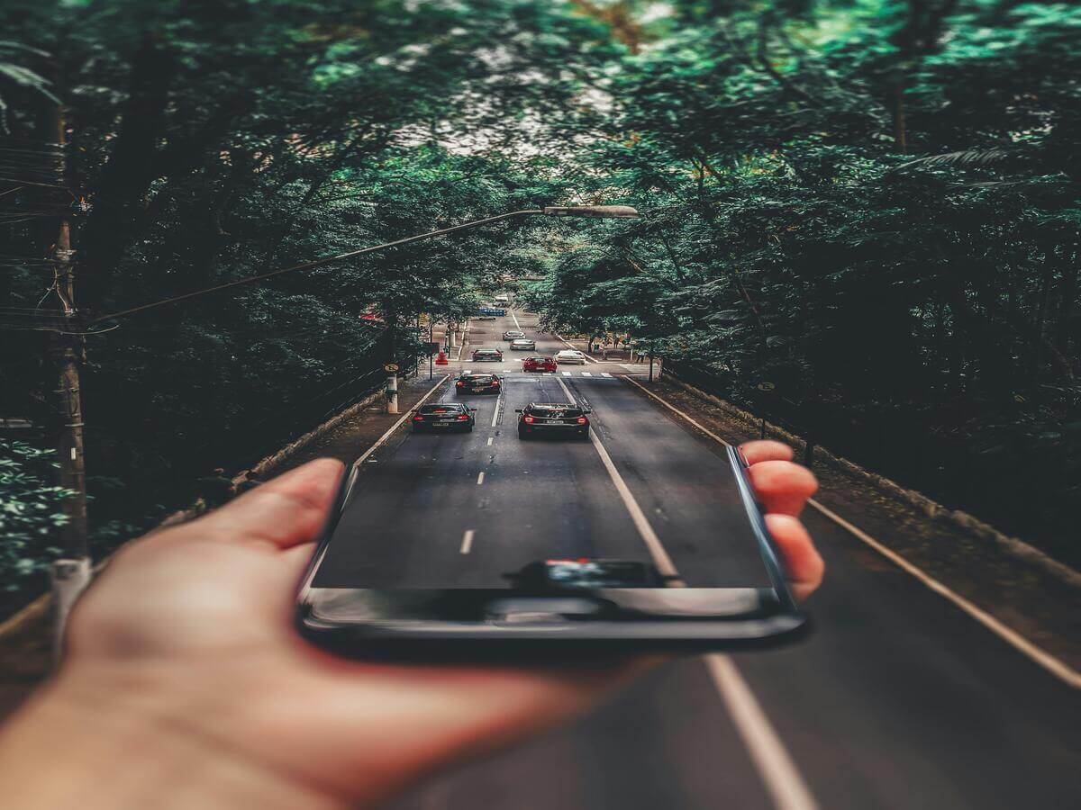 Using a smartphone navigation app to plan a road trip route through scenic travel destinations.