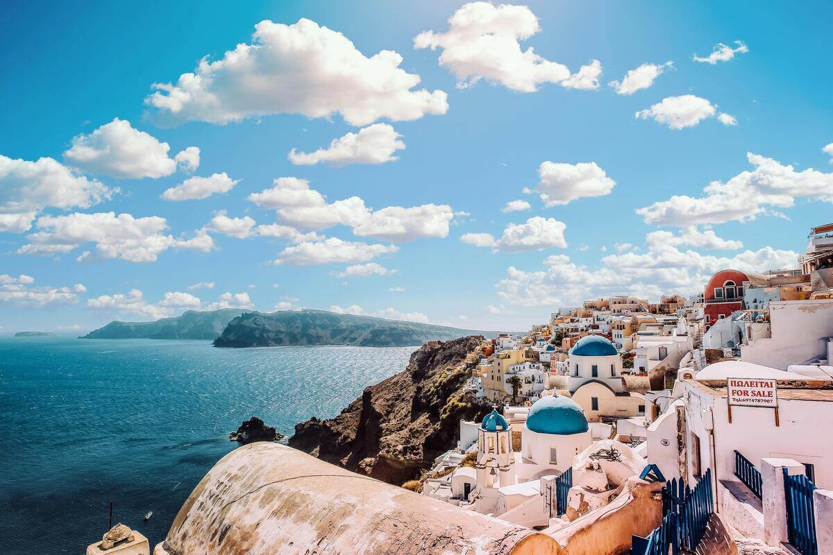 Santorini caldera view with white buildings and blue domes overlooking the Aegean Sea, one of the most romantic destinations in Europe for couples