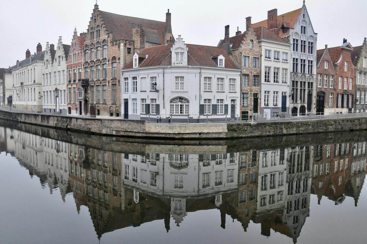 Historic canal houses reflecting on the water in Bruges, one of the most romantic cities in Europe