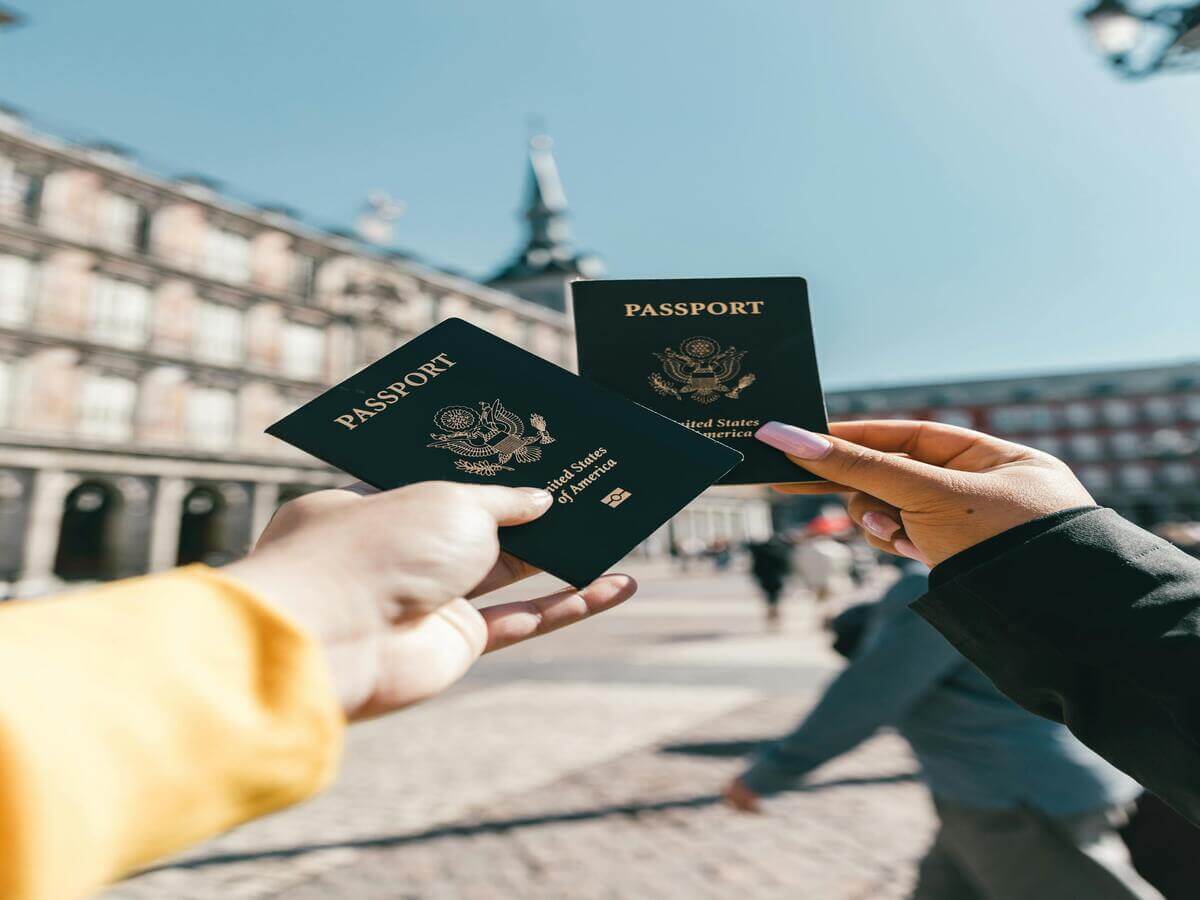 Couple holding passports while travelling in Europe starting their two week Europe travel adventure.