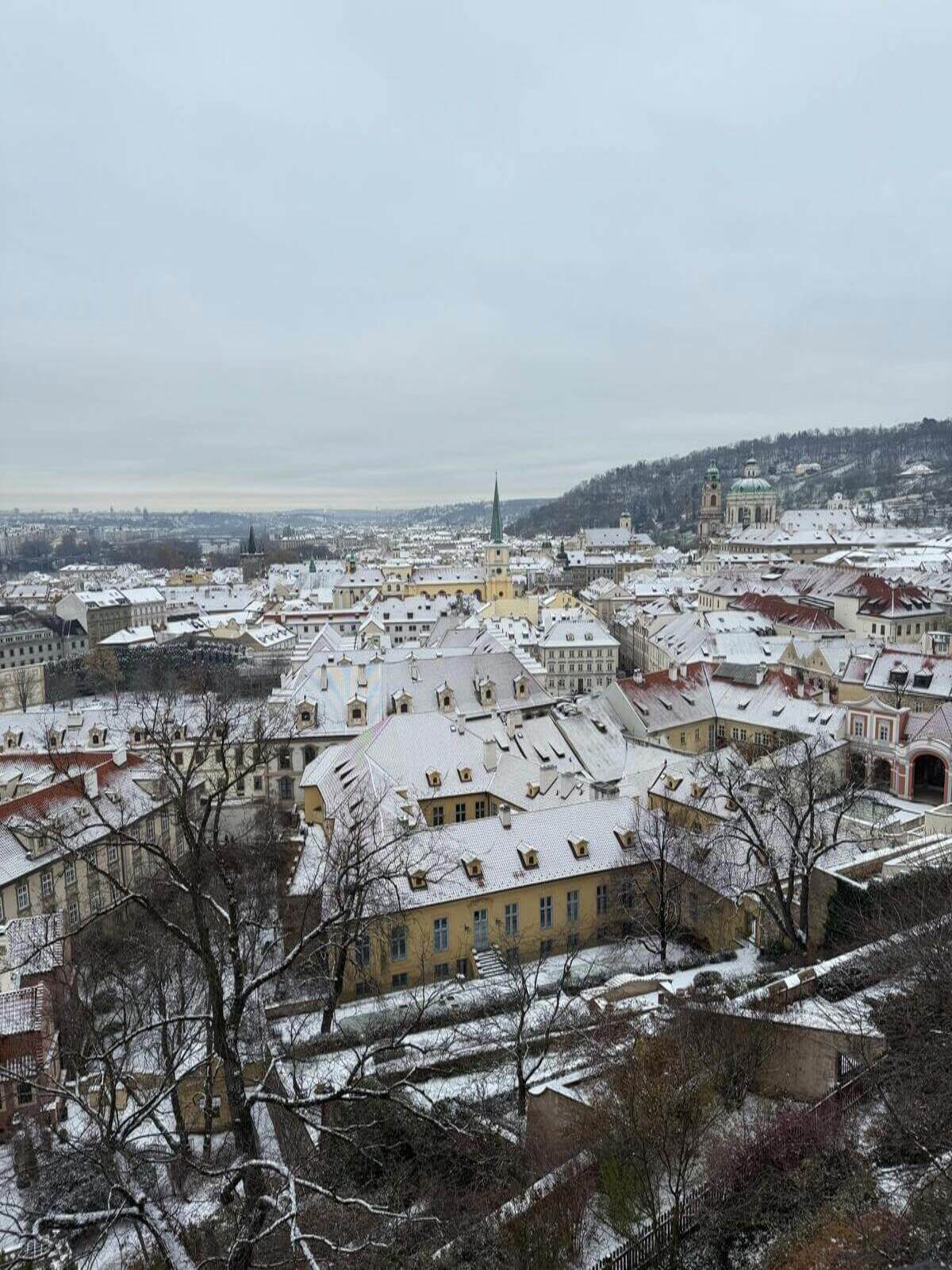 Panoramic view of a European city covered in snow with historic buildings and rooftops in winter