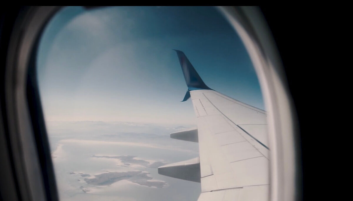 View from airplane window over coastline during a Europe flight, capturing travel journey experience  