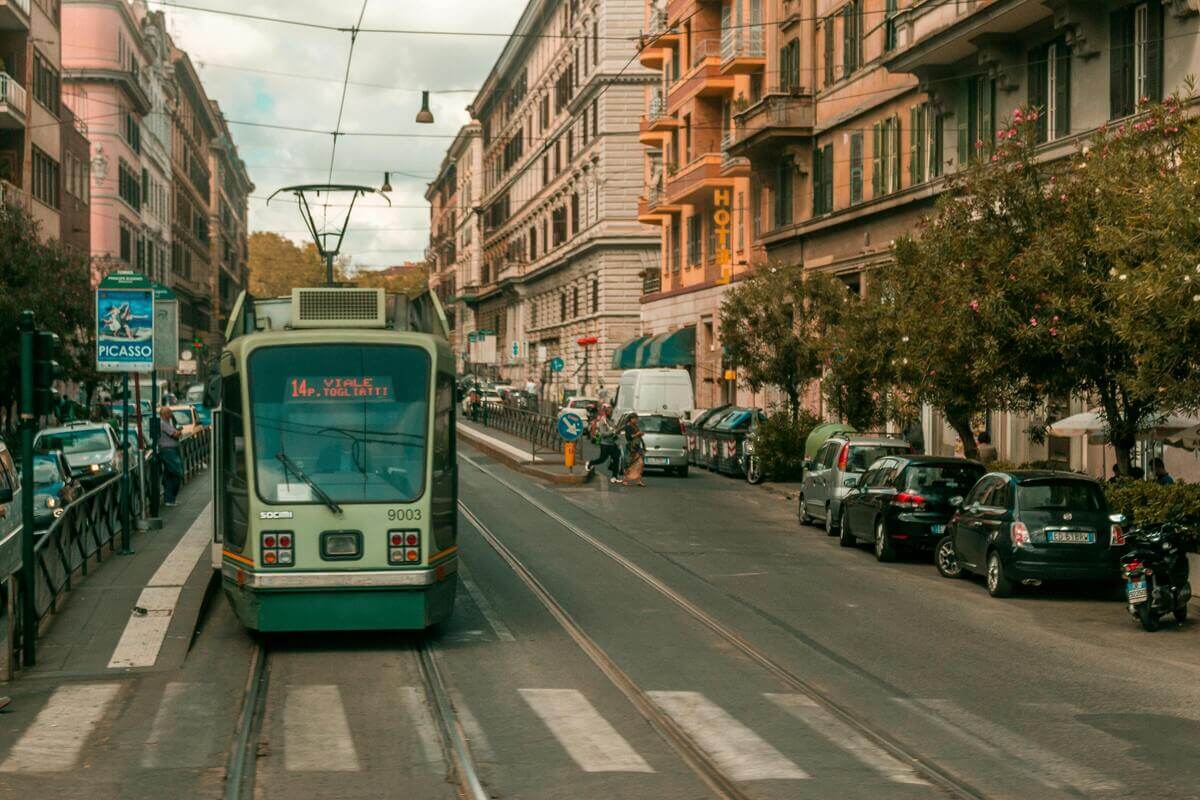 Traditional tram travelling through a busy street in central Rome, Italy.