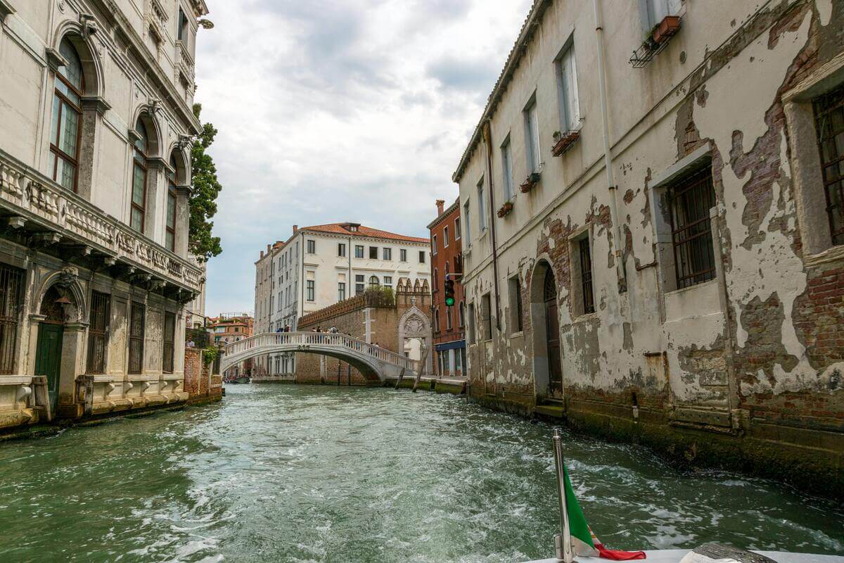 Scenic canal and historic bridge viewed from a boat in Venice, Italy.